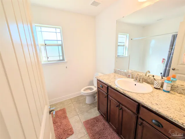 a bathroom with a granite countertop sink toilet and mirror