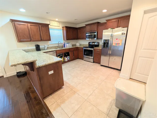a kitchen with stainless steel appliances granite countertop a refrigerator stove a sink and dishwasher