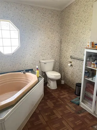 a bathroom with a sink a toilet a window and mirror