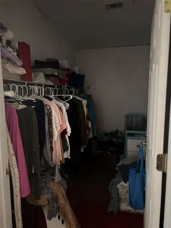 a view of walk in closet with clothes and shoes