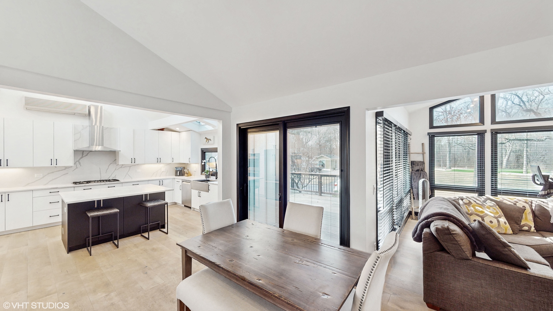 15160 West Oak Spring Road Libertyville, IL 60048 - Photo 9 of 36 a large living room with stainless steel appliances granite countertop a stove top oven a sink dishwasher a dining table and chairs with wooden floor