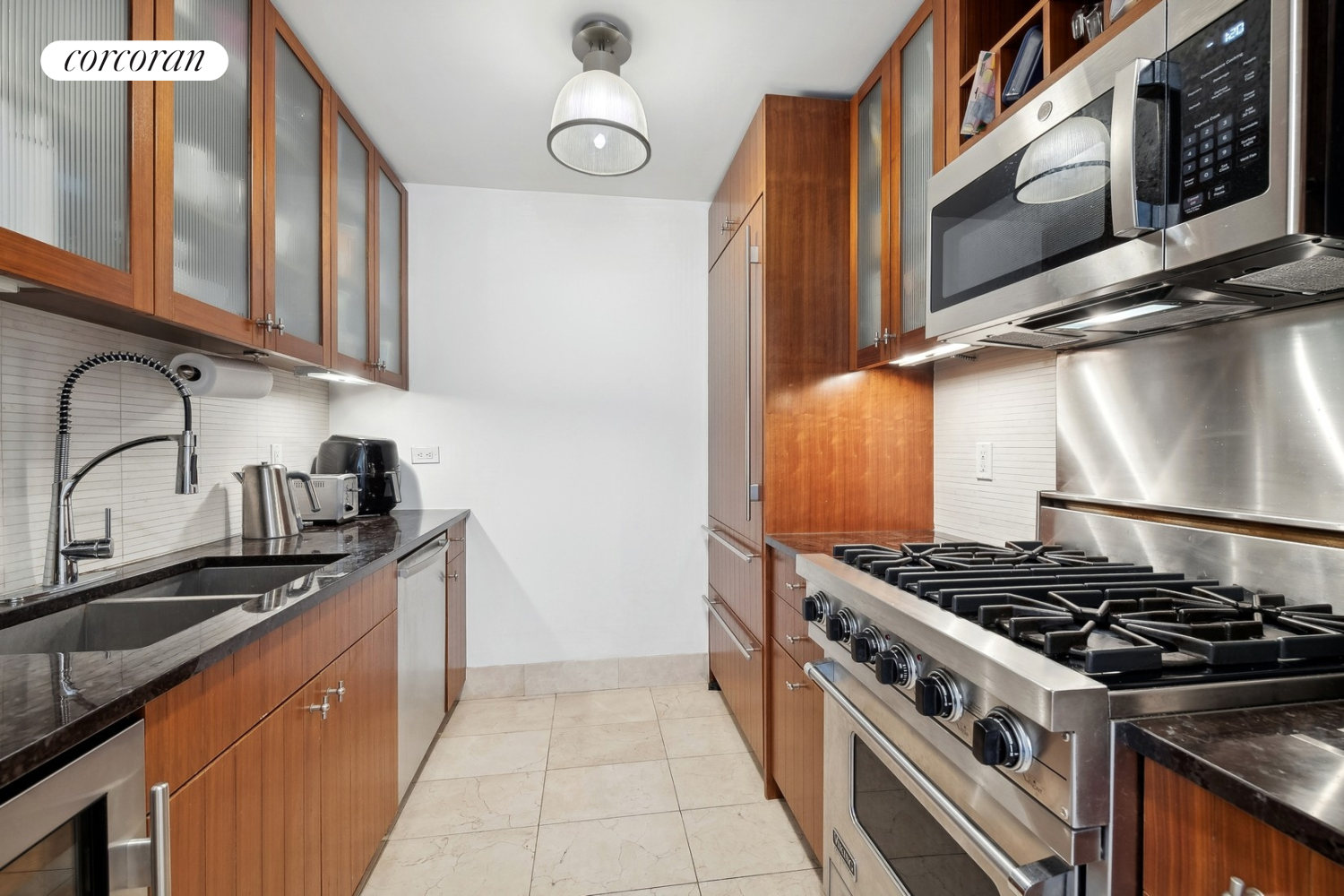 250 East 53rd Street, Unit 1403 Manhattan, NY 10022 - Photo 3 of 10 a kitchen with stainless steel appliances granite countertop a stove and a sink