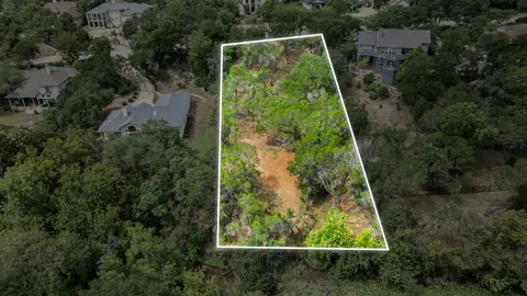 an aerial view of residential house with outdoor space and trees all around