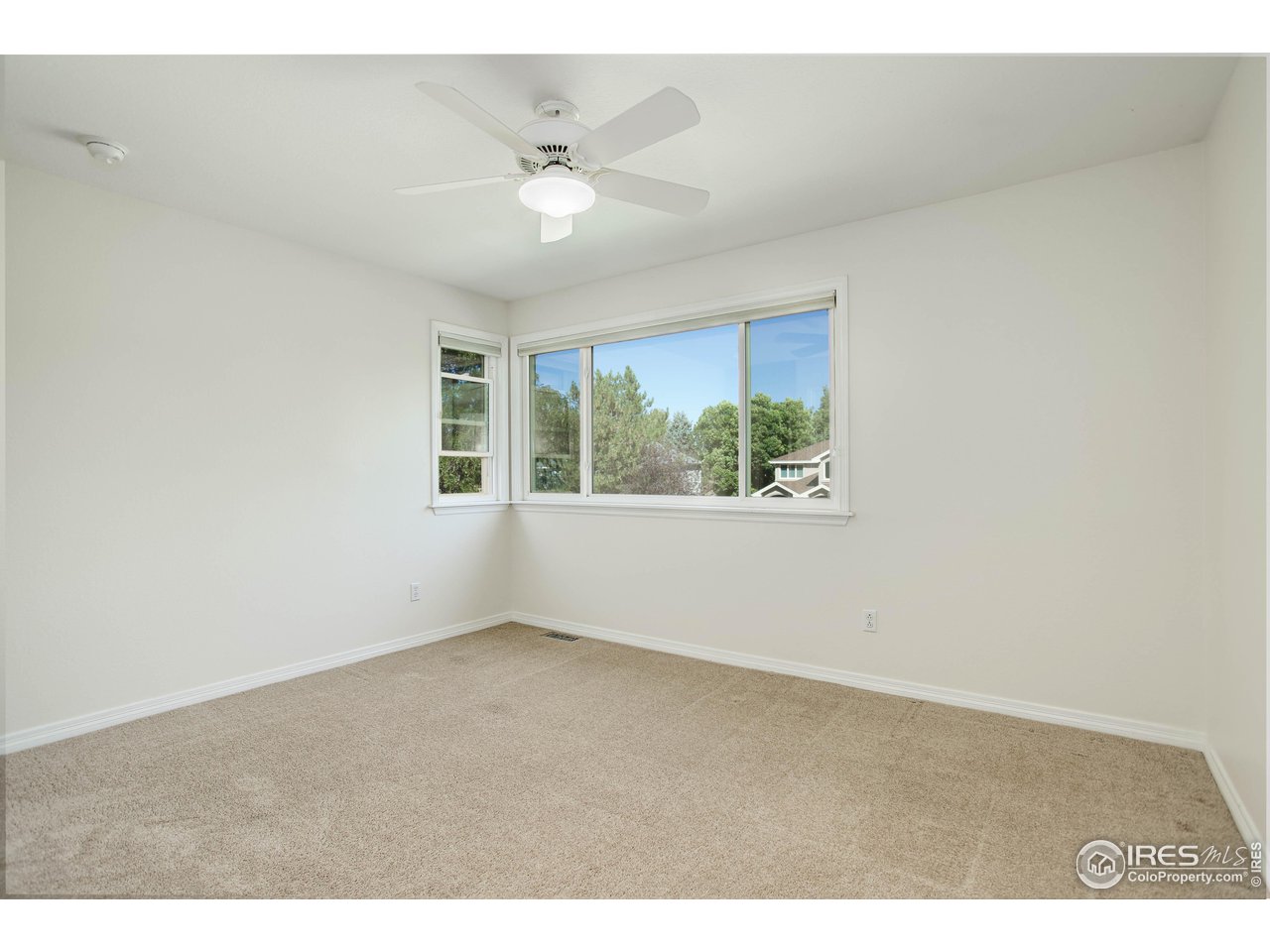 7346 Augusta Drive Boulder, CO 80301 - Photo 27 of 40 an empty room with windows and chandelier fan