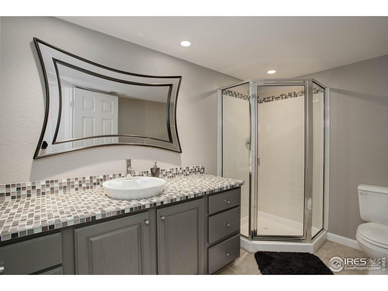7346 Augusta Drive Boulder, CO 80301 - Photo 35 of 40 a bathroom with a granite countertop sink mirror vanity and toilet