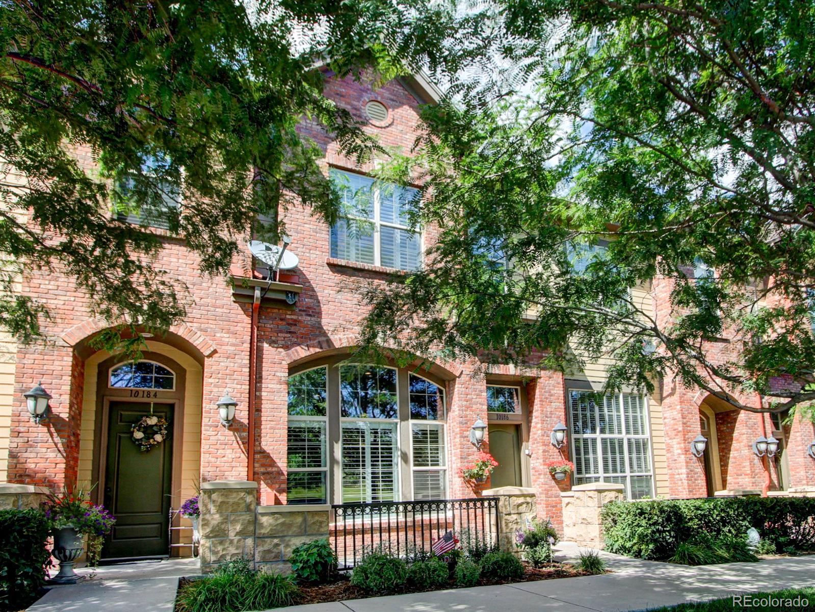 front view of a brick house with a large tree