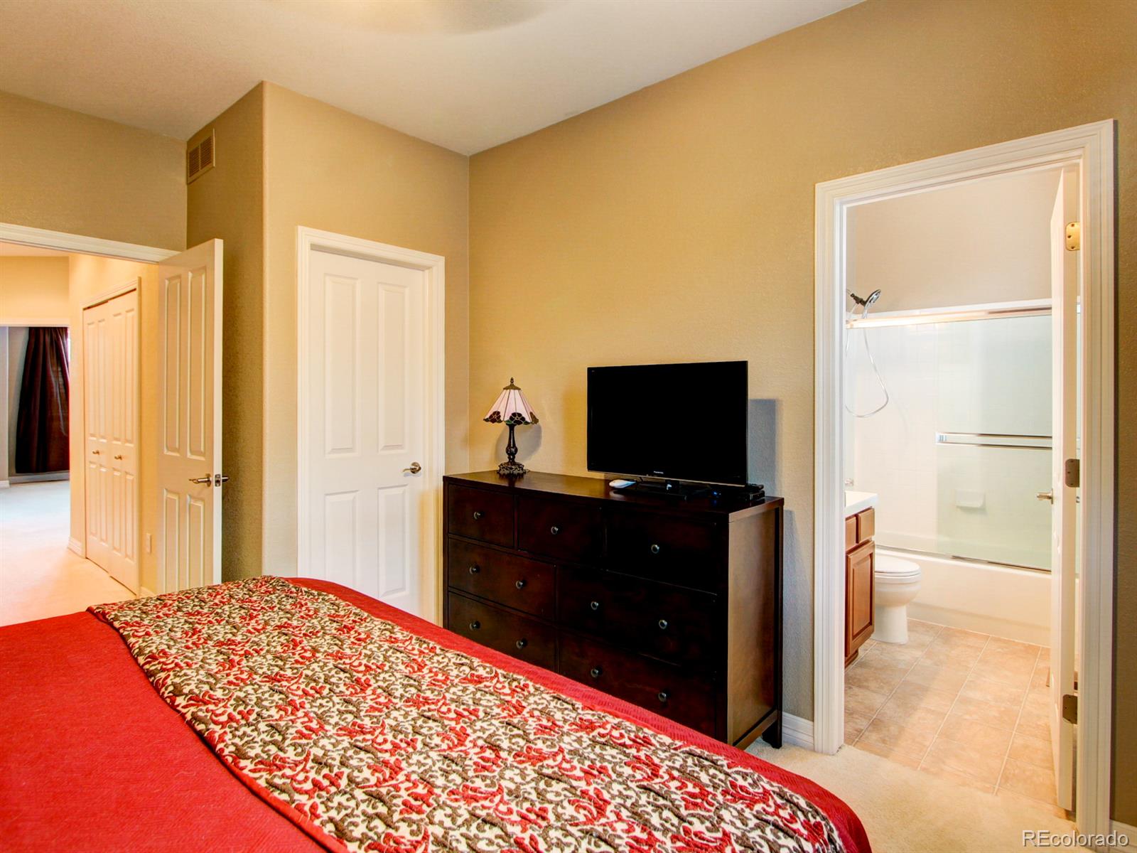 10186 RidgeGate Circle Lone Tree, CO 80124 - Photo 19 of 24 a bedroom with a bed and a flat screen tv