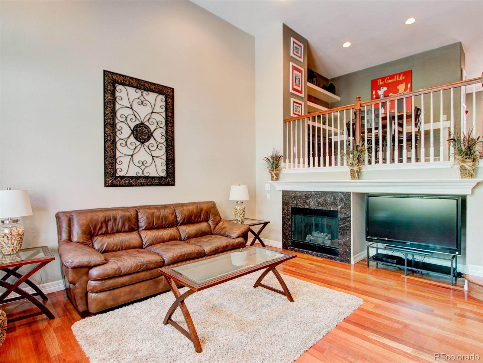 10186 RidgeGate Circle Lone Tree, CO 80124 - Photo 2 of 24 a living room with furniture a flat screen tv and a fireplace