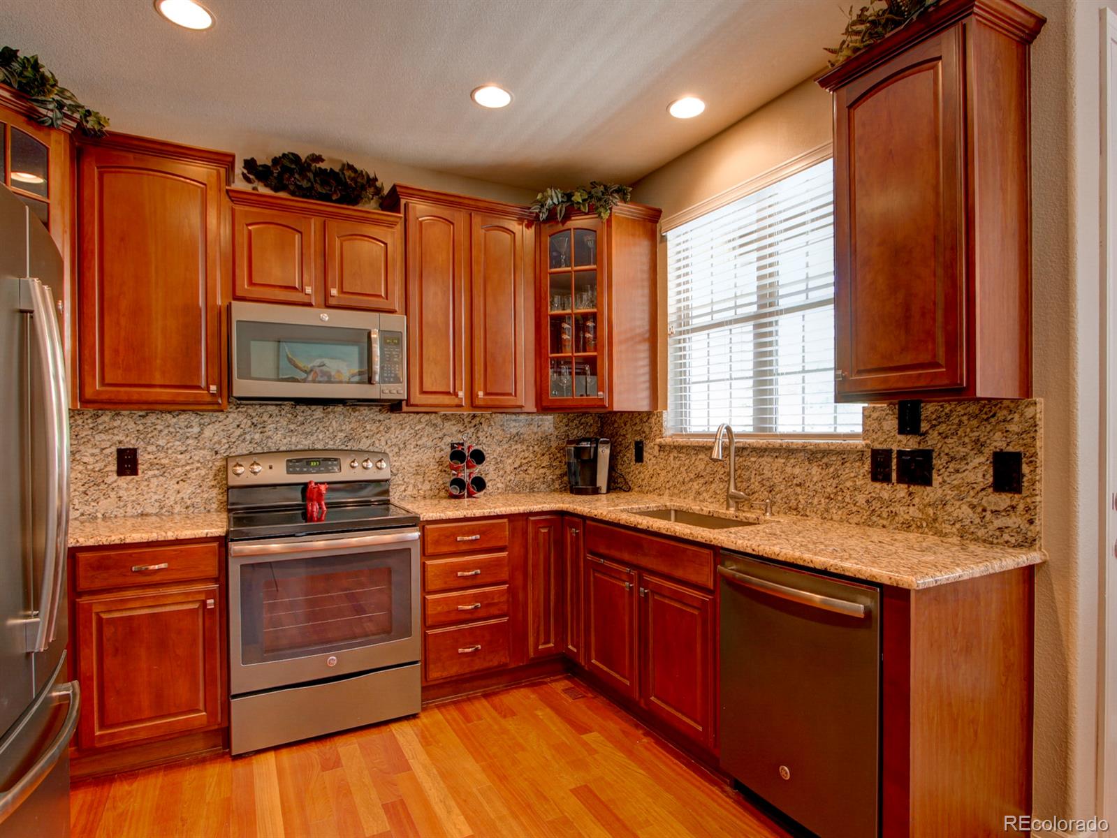 10186 RidgeGate Circle Lone Tree, CO 80124 - Photo 10 of 24 a kitchen with stainless steel appliances granite countertop wooden cabinets and a stove top oven