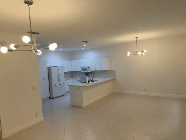 a kitchen with kitchen island white cabinets and refrigerator