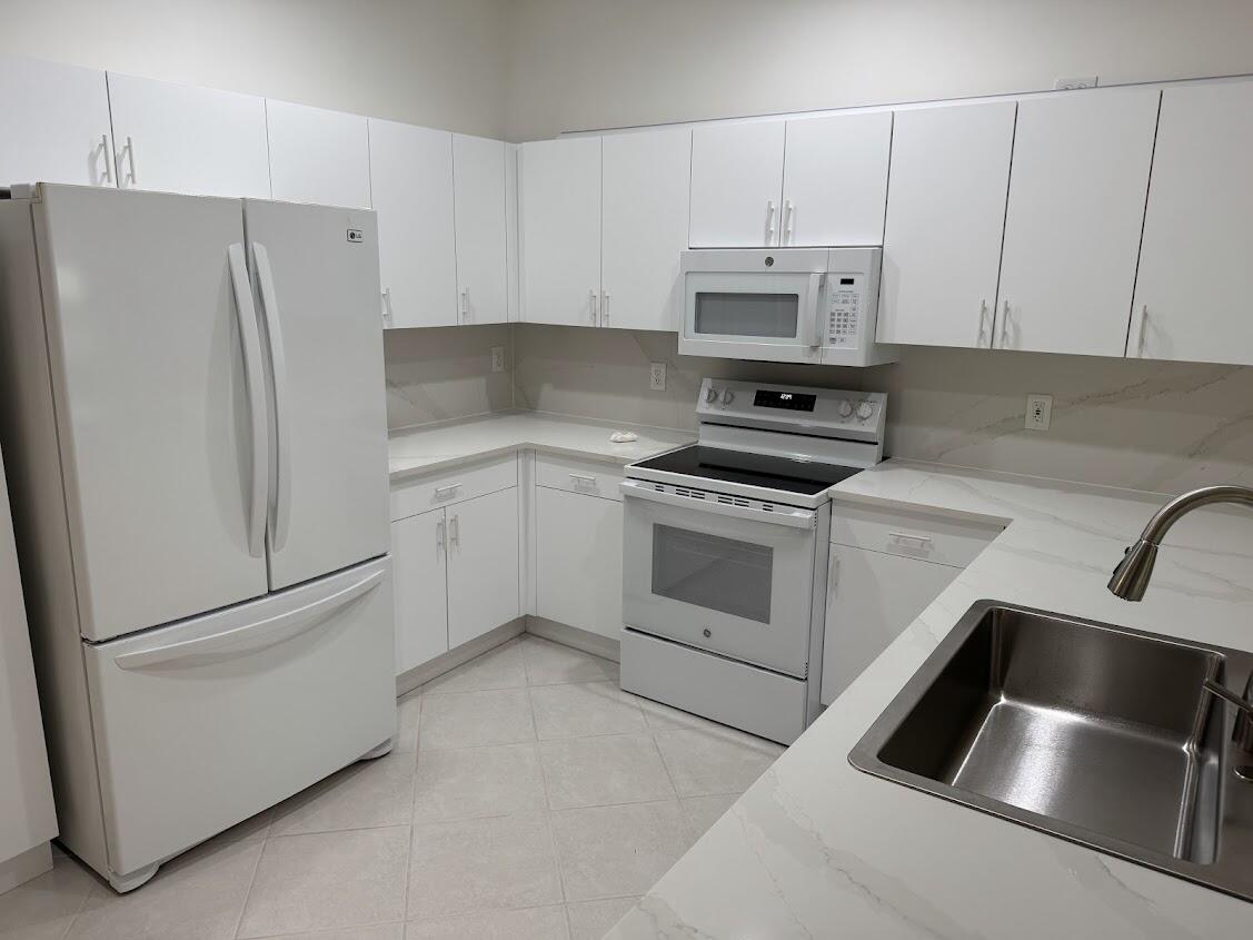 18237 Boca Way Drive Boca Raton, FL 33498 - Photo 12 of 36 a kitchen with white cabinets and white stainless steel appliances