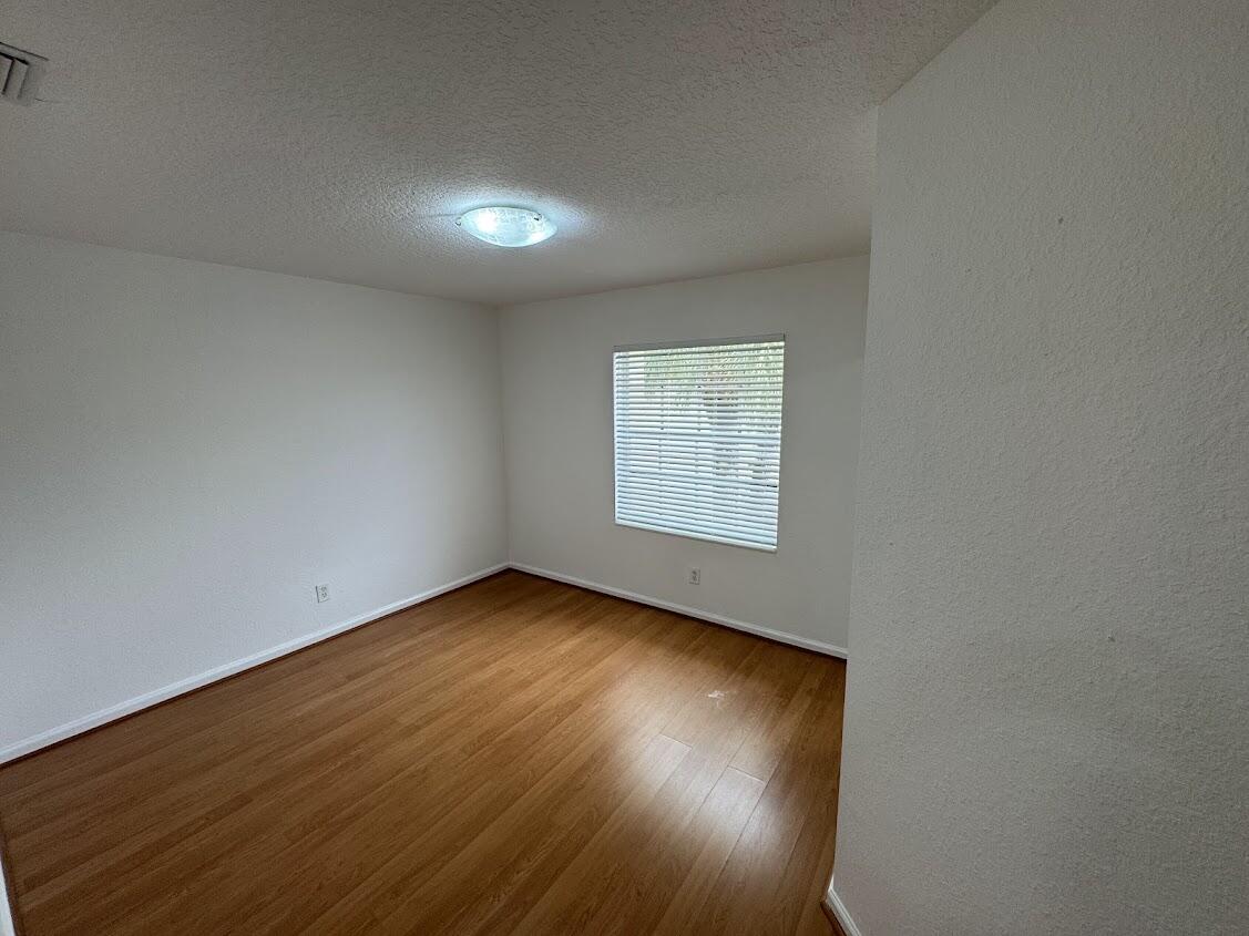 18237 Boca Way Drive Boca Raton, FL 33498 - Photo 22 of 36 an empty room with wooden floor and windows