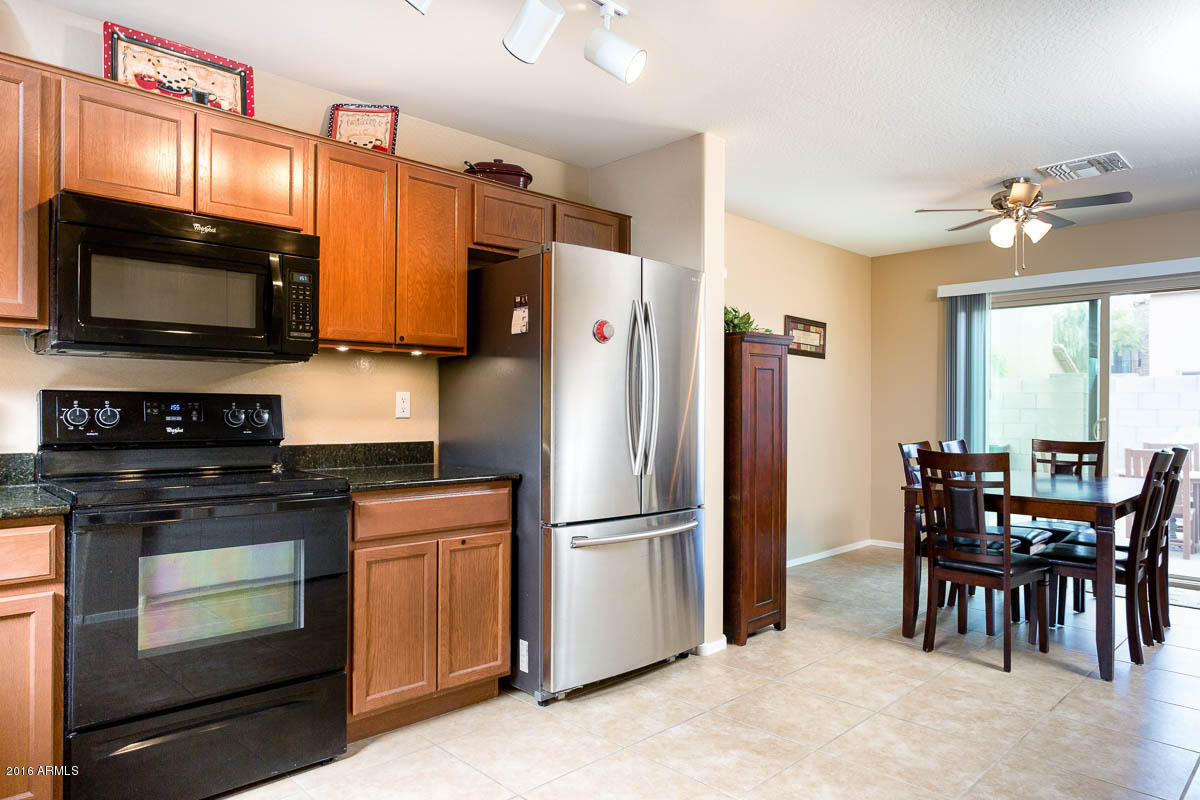 2676 South De Soto Road Apache Junction, AZ 85119 - Photo 5 of 19 a kitchen with stainless steel appliances granite countertop a stove a refrigerator a dining table and chairs
