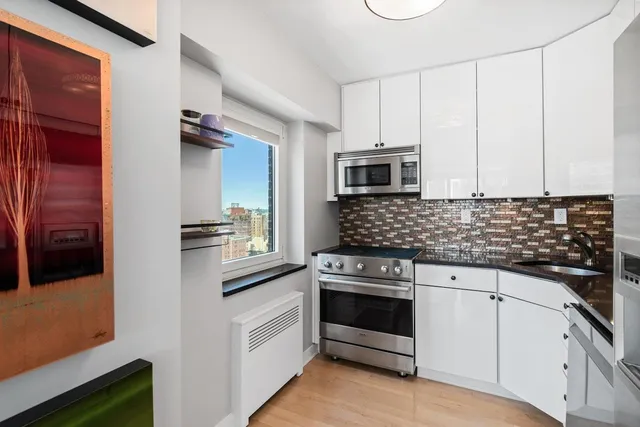 a kitchen with white cabinets and appliances