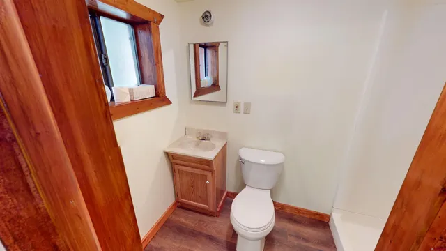a white toilet sitting next to a sink and a mirror
