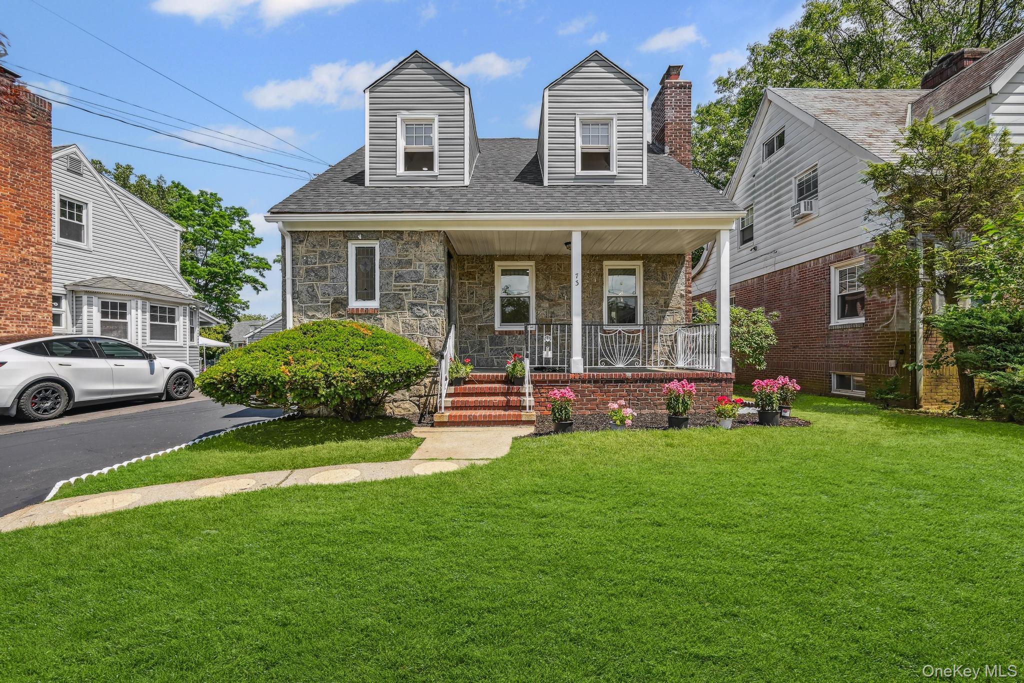 a view of a brick house with a big yard and large windows