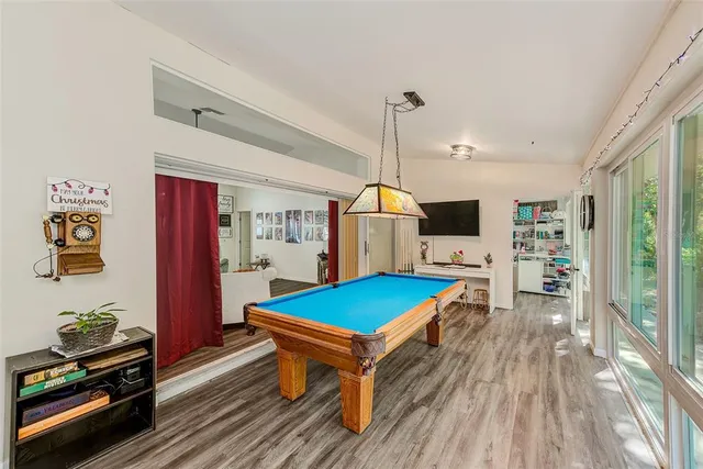 a living room with a table chairs and a kitchen view