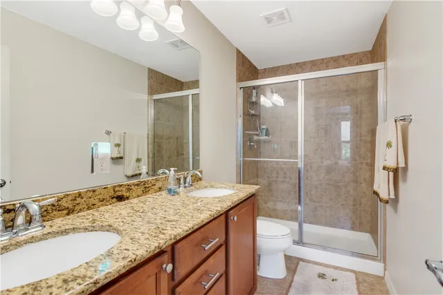 a bathroom with a granite countertop sink toilet and shower