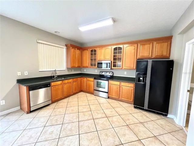 a kitchen with granite countertop stainless steel appliances a stove sink and cabinets