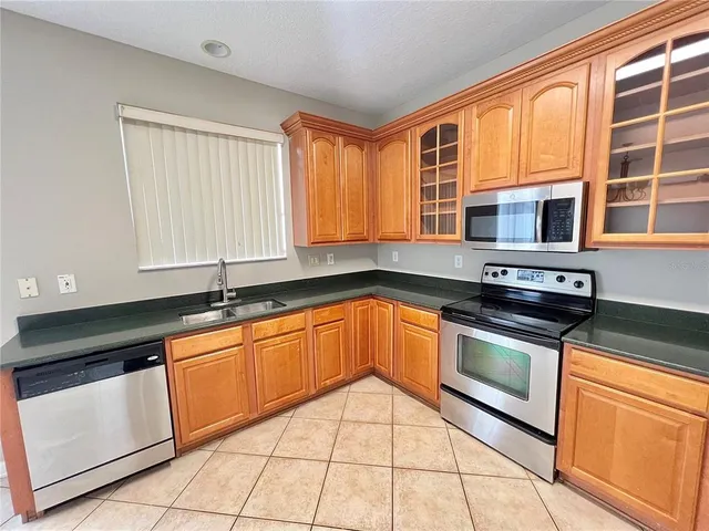 a kitchen with stainless steel appliances granite countertop a refrigerator and a stove top oven