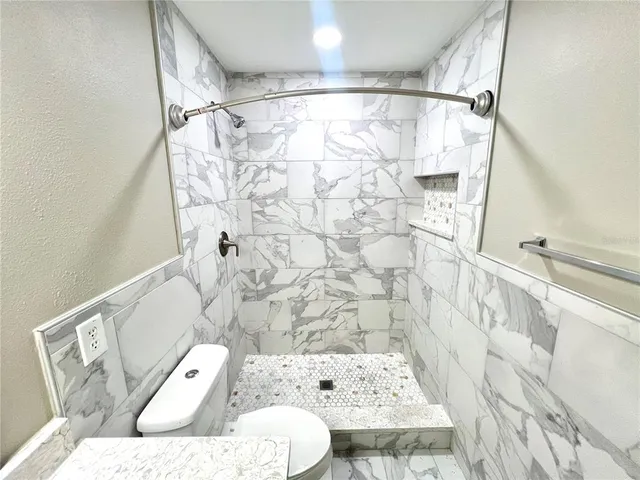 a white toilet sitting next to a bathroom sink