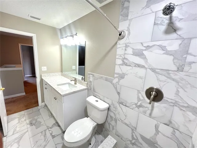 a bathroom with a sink a toilet and a mirror