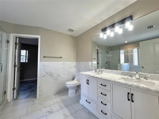 a spacious bathroom with a toilet sink and mirror