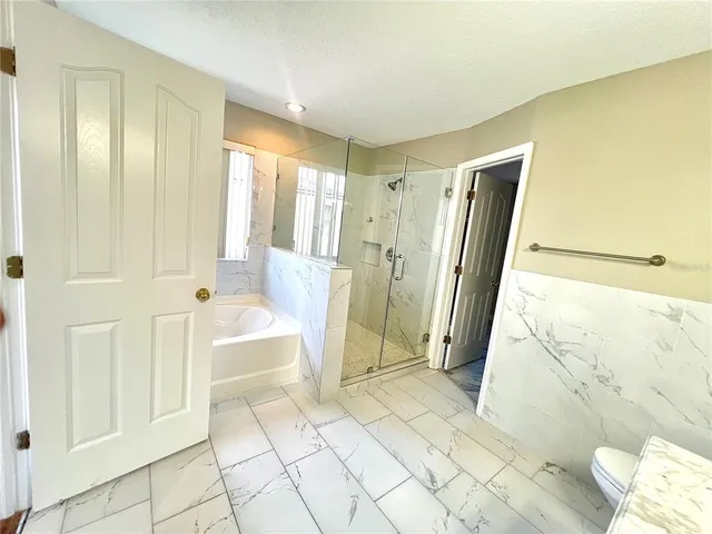 a spacious bathroom with a tub sink and shower