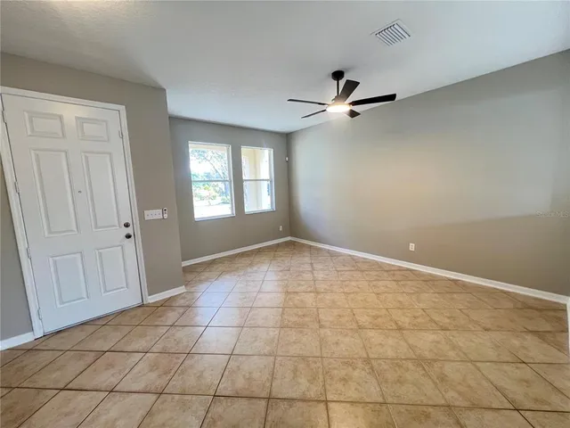 an empty room with windows and fan