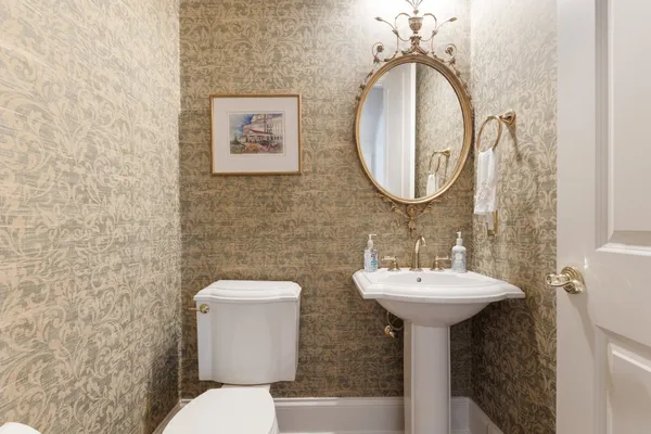 a bathroom with a toilet sink and mirror