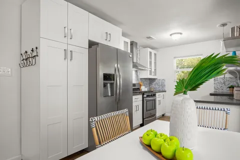 a kitchen with stainless steel appliances granite countertop a refrigerator a stove a sink and dishwasher