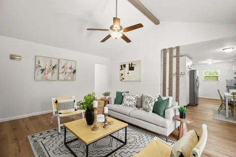a living room with furniture and a wooden floor