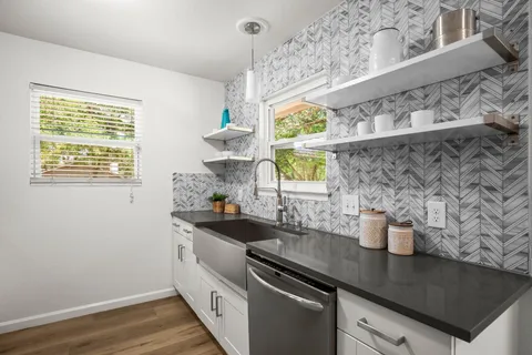 a kitchen with a sink a window and cabinets