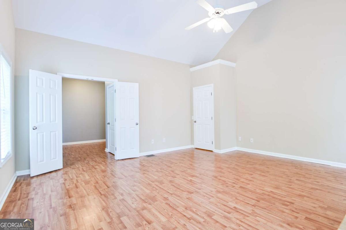 170 Meredith Ridge Road, Unit 8 Athens, GA 30605 - Photo 28 of 52 a view of a livingroom with wooden floor and a ceiling fan