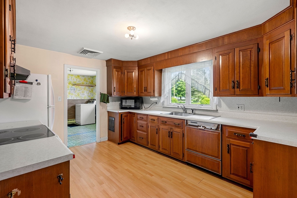30 Bailey Road Andover, MA 01810 - Photo 3 of 37 a kitchen with stainless steel appliances granite countertop wooden cabinets a sink dishwasher a stove and a refrigerator with wooden floor