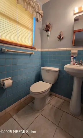 a bathroom with a toilet a sink and mirror