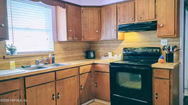 a kitchen with stainless steel appliances granite countertop white cabinets and a stove top oven