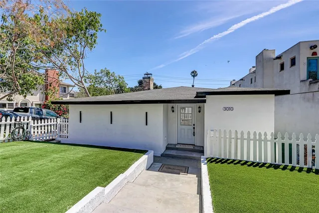 a front view of a house with a garden and yard