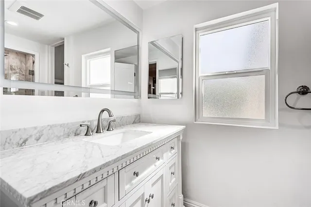 a bathroom with a sink vanity granite and a mirror