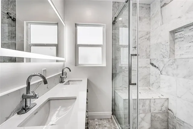 a bathroom with a sink a window and a shower
