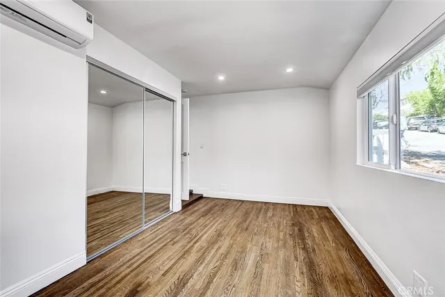 a view of hallway with a large window and wooden floor