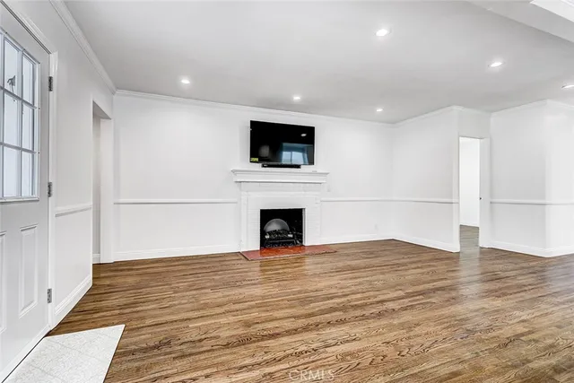 a view of a livingroom with wooden floor and a fireplace