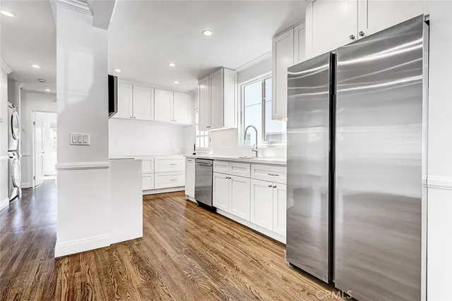 a kitchen with kitchen island white cabinets and stainless steel appliances