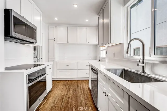 a kitchen with stainless steel appliances granite countertop a sink a stove and a microwave