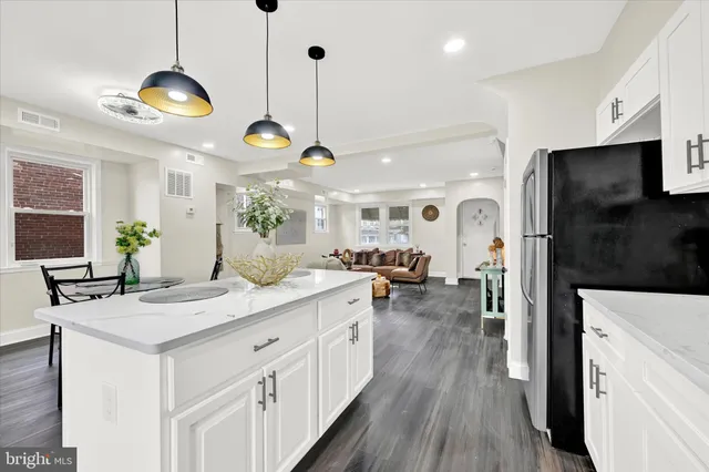 a kitchen with stainless steel appliances granite countertop a stove a sink and a wooden floor