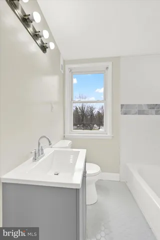 a bathroom with a sink a large mirror and a bathtub