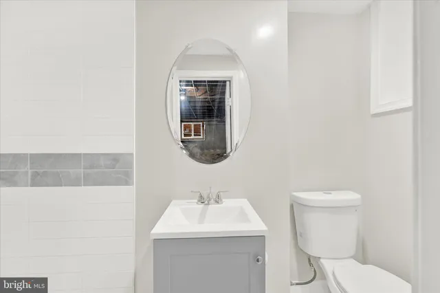 a bathroom with a toilet sink and mirror