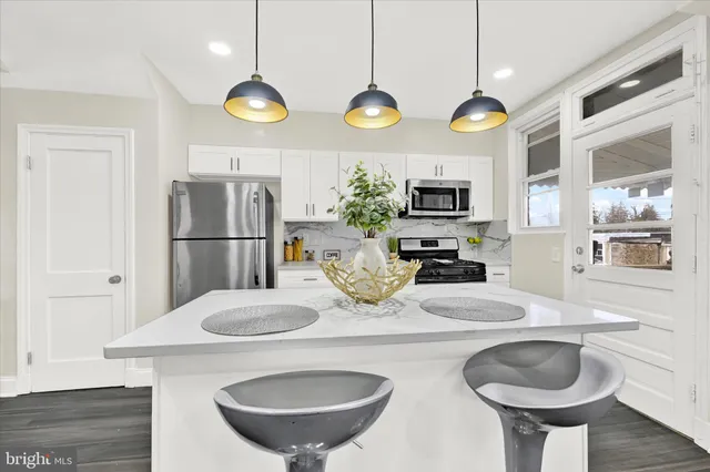 a kitchen with stainless steel appliances granite countertop a sink and a refrigerator