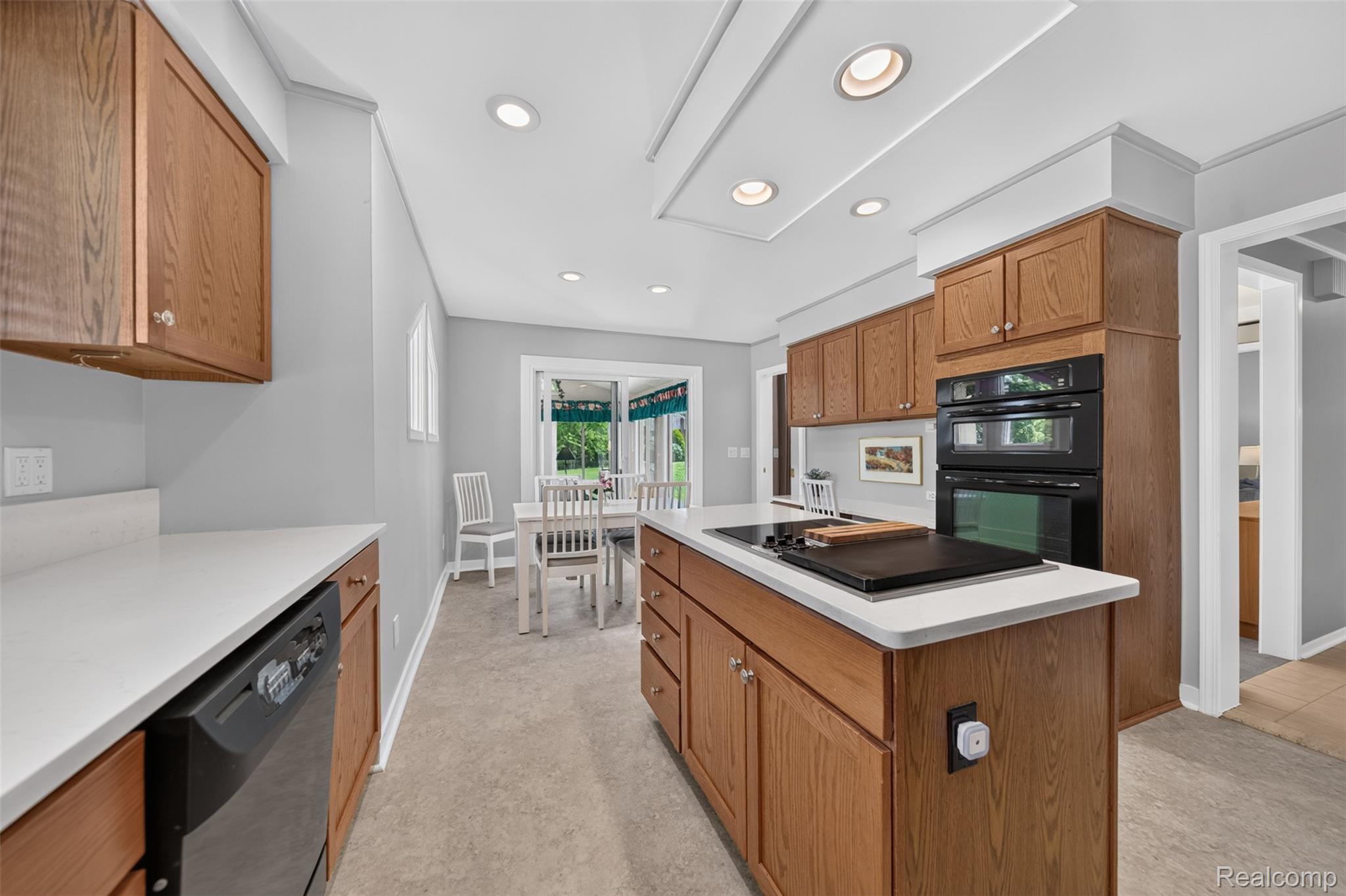 1236 Chaffer Drive Rochester, MI 48306 - Photo 16 of 76 Kitchen featuring a central island with cooktop, wood cabinetry, white countertops, and built-in double ovens