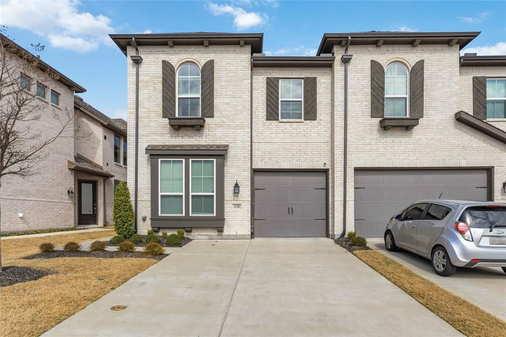 1128 Queensdown Way Forney, TX 75126 - Photo 1 of 30 Light brick exterior with contrasting dark trim, featuring a single-car garage